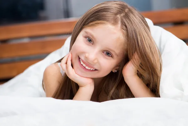 Güzel küçük bir kız bir battaniyenin altında — Stok fotoğraf