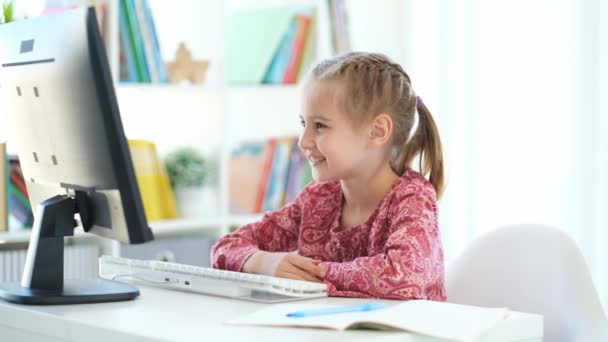 小さな女の子は、コンピュータ上のウェブカメラを介して話す — ストック動画