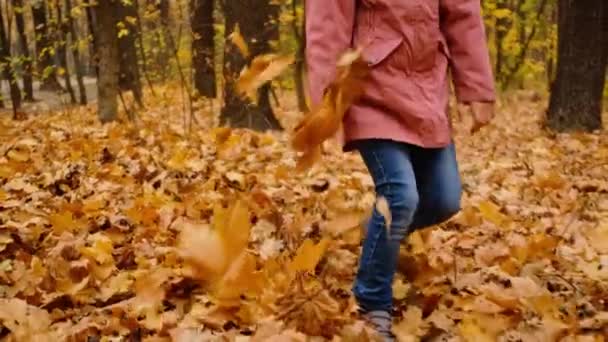 Κορίτσι που πετάει φύλλα με τα πόδια της — Αρχείο Βίντεο