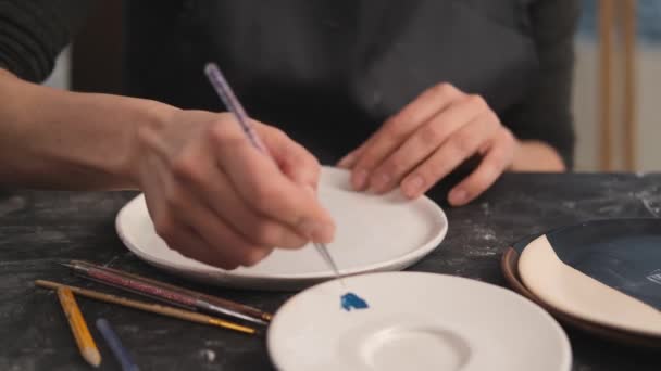 Woman drawing oil pattern on plate — Stock Video
