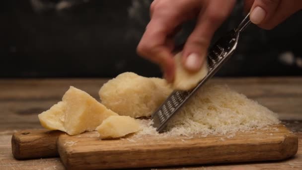 Woman using grater on cheese piece — Stock Video