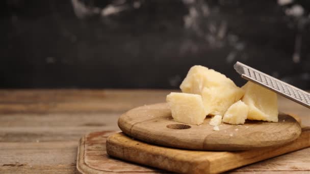 Parmezán sajt darabok a reszelő mellett — Stock videók