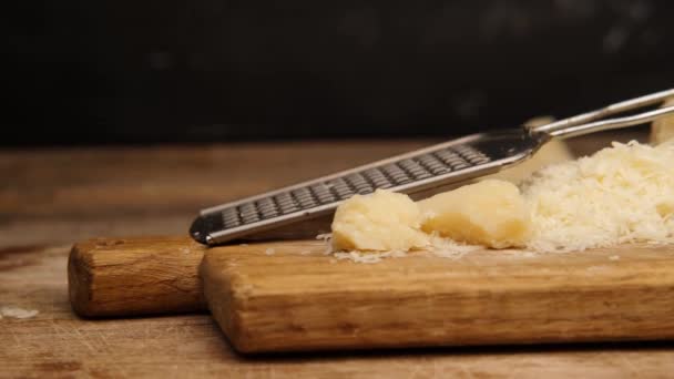 Queijo ralado deitado ao lado de pedaços de parmesão — Vídeo de Stock