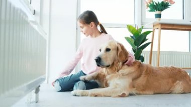 Golden Retriever köpeğiyle oturan küçük kız