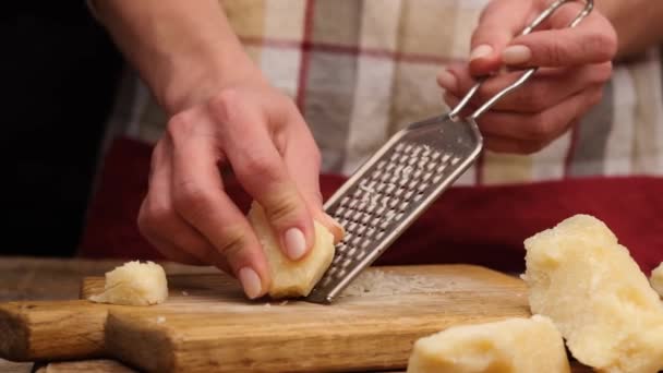 Γυναίκα τρίβει κομμάτια τυριού παρμεζάνας — Αρχείο Βίντεο
