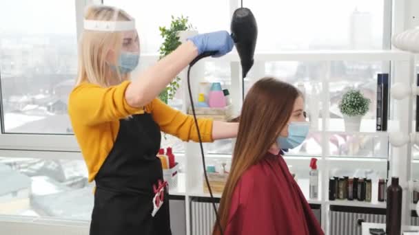 Frisör i mask bryr sig hår klient med hårtork — Stockvideo