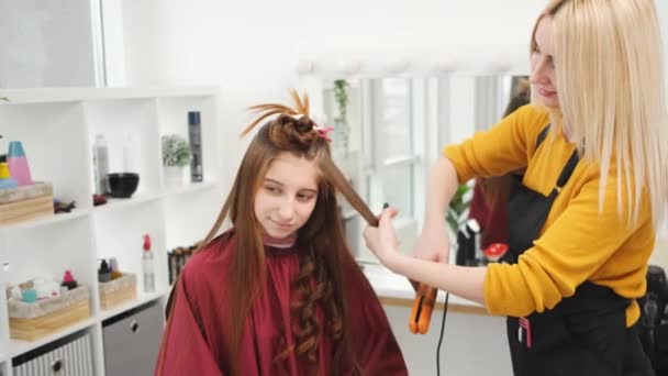 Hairdresser curls long hair — Stock Video