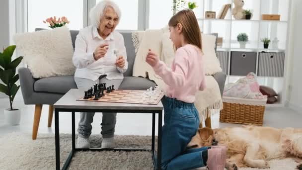 Бабушка играет в шахматы с внучкой — стоковое видео