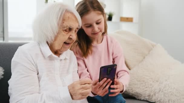Внучка и бабушка со смартфоном — стоковое видео