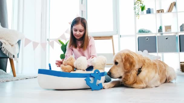 Ragazza che gioca con giocattoli e cane golden retriever — Video Stock