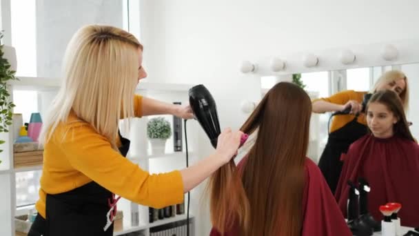 Kuaför saç kurutma makinesiyle müşterinin saçını önemser. — Stok video