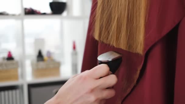 Frisör trimmar hårtoppar med hårklippare — Stockvideo