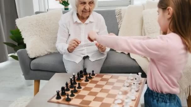 Бабушка играет в шахматы с внучкой — стоковое видео
