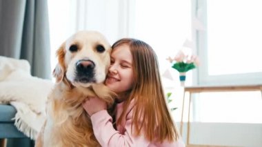 Golden retriever köpeğini okşayan küçük kız.