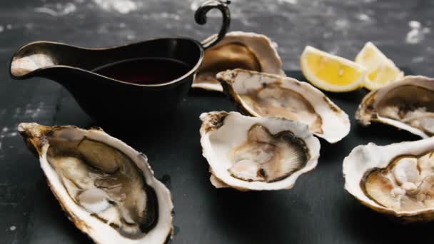 Oesters met citroen op zwarte plaat — Stockvideo