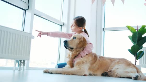 Kislány ül Golden retriever kutya — Stock videók