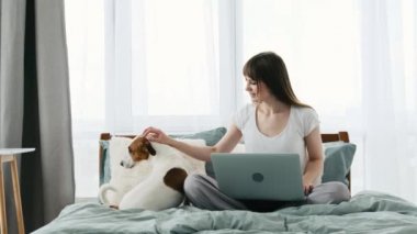 Yatağında köpek ve defter olan kız.