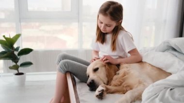 Yatağında golden retriever köpeği olan kız