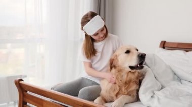 Yatağında golden retriever köpeği olan kız