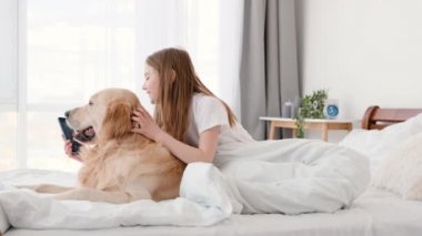 Golden Retriever köpeği ve akıllı telefonu olan kız.
