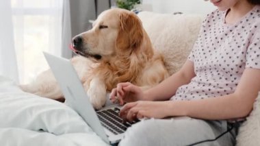Dizüstü bilgisayarı ve golden retriever köpeği olan kız.