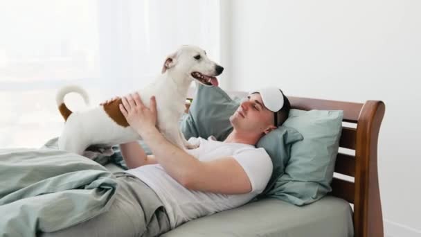 Mand med hund i sengen – Stock-video