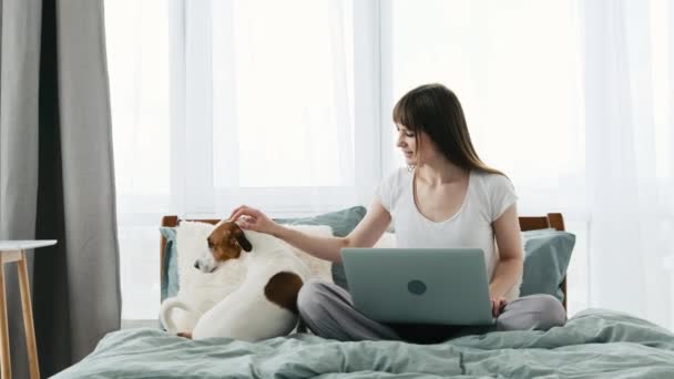 Menina com cão e caderno na cama — Vídeo de Stock