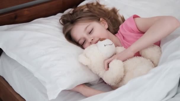 Yatağında oyuncak ayı olan bir çocuk. — Stok video