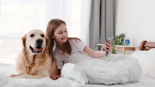 Fata cu câine de aur retriever și smartphone — Videoclip de stoc