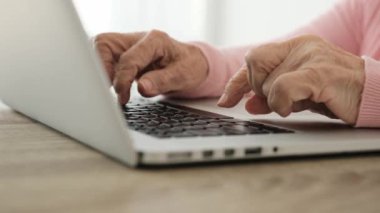Dizüstü bilgisayarı olan yaşlı bir kadın.