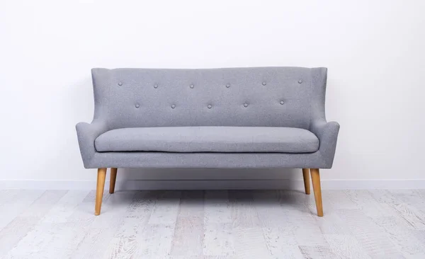 Graue Couch auf hellem Laminatboden — Stockfoto