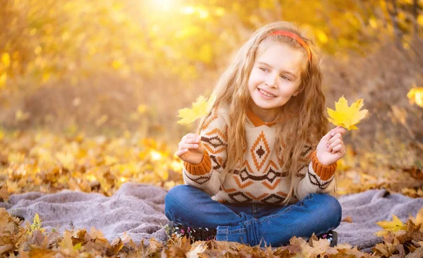 Menina segurando folhas amarelas — Fotografia de Stock