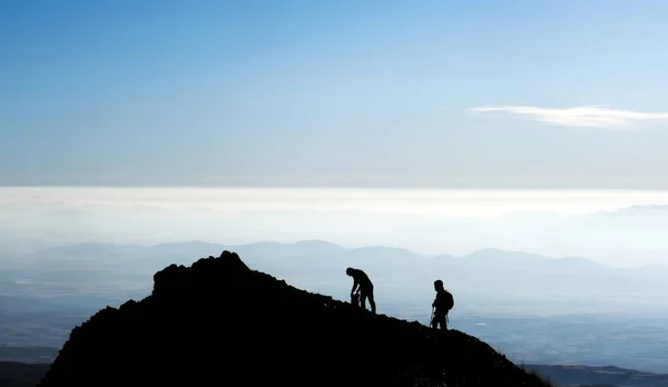 Silhouette di escursionisti in cima alla montagna — Foto Stock