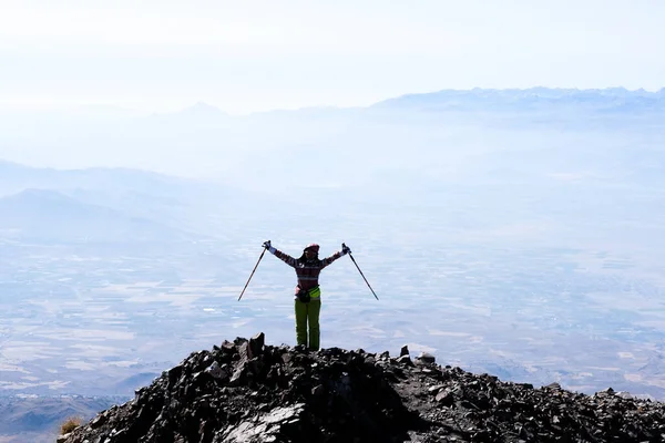 Turista en la cima de la montaña con las manos levantadas — Foto de Stock