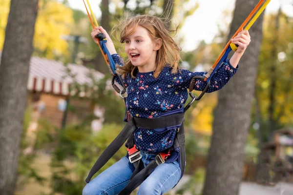 Glückliches kleines Mädchen jongliert auf Trampolinseilen — Stockfoto