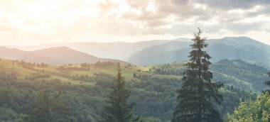 Bulutlu gökyüzünün altındaki dağların panoramik görüntüsü