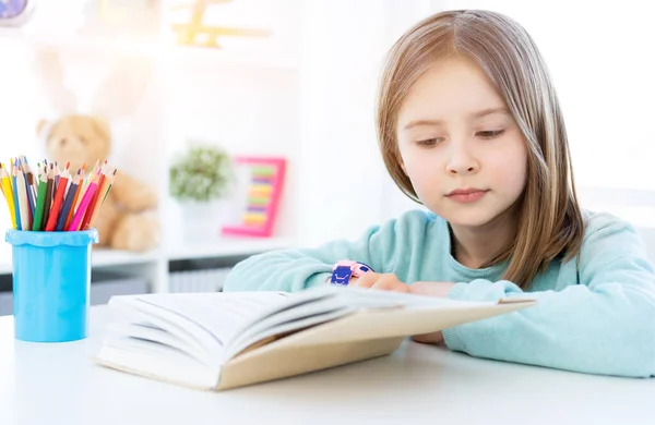 Kitap okuyan sevimli küçük bir kız. — Stok fotoğraf