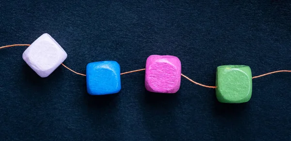 Wooden cube beads on thread — Stock Photo, Image