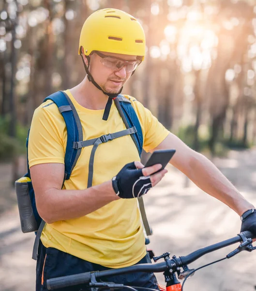 Uomo che utilizza smartphone con mappa durante il ciclismo — Foto Stock