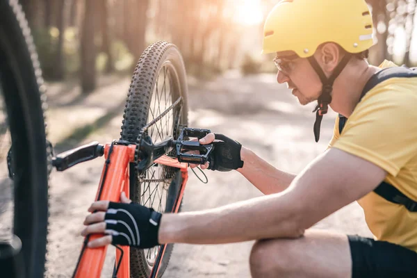 Чоловік перевіряє механізм ланцюга на велосипеді — стокове фото