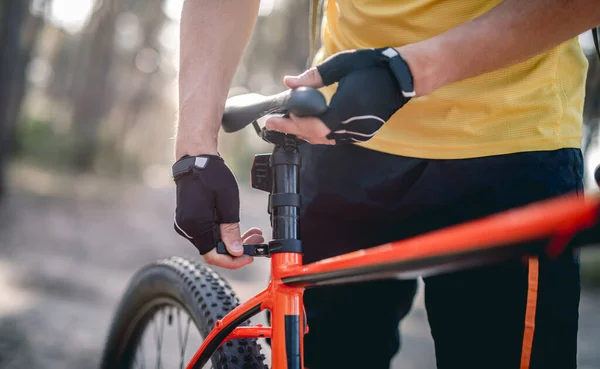 Jinete ajustando la altura del asiento en bicicleta — Foto de Stock
