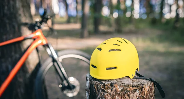 Bicycle helmet on stump in forest — Stock Photo, Image