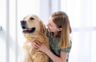 Golden retriever köpeği olan bir kız çocuğu