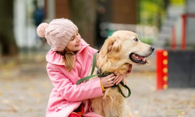 Golden retriever köpeği olan küçük bir kız.