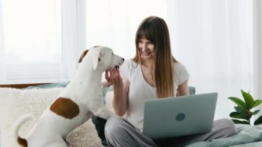 Yatağında köpek ve defter olan kız.