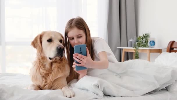 Flicka med golden retriever hund och smartphone — Stockvideo