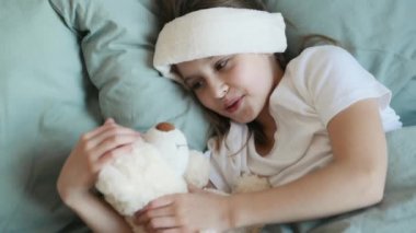 Oyuncak ayı ve ateşi olan bir kız.