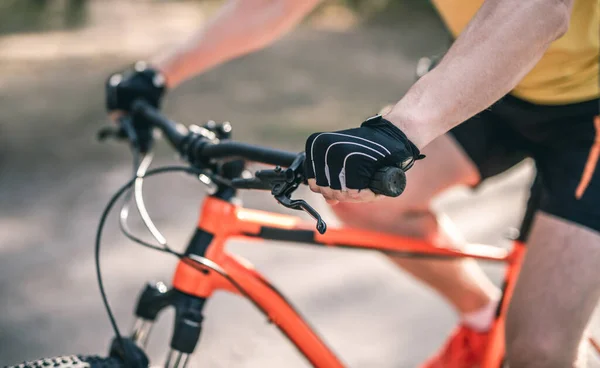Ręce w rękawiczkach na kierownicy roweru — Zdjęcie stockowe