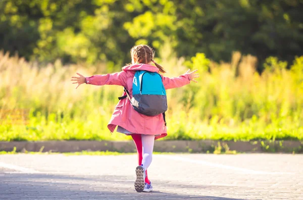 Mädchen mit Rucksack läuft mit offenen Armen — Stockfoto