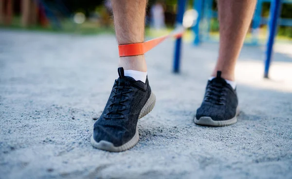 Male legs training with elastic rubber — Stock Photo, Image